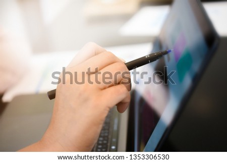 Woman hand is holding pen and pointing at screen for online shopping.Online shopping concept.Close up