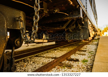 Vintage rusty train wheels with chains hanging on the railway track, old fashioned