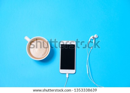 Music or podcast background with headphones on blue table, flat lay. Top view, flat lay

