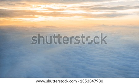 Aerial traveling. Wonderful view of the sky and clouds with the twilight from above, as seen through an airplane window. Morning mist. Flying at dusk or dawn. Fly through orange cloud and sun.