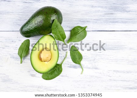 Slices of avocado on white background. Whole and half with leaves.