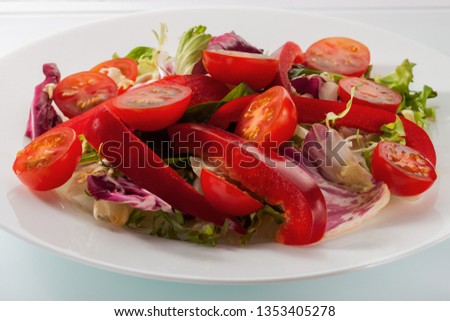 Salad with fresh vegetables on a white table