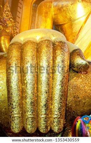 The Big gold finger of Buddha with gold foil in Thailand temple. close up