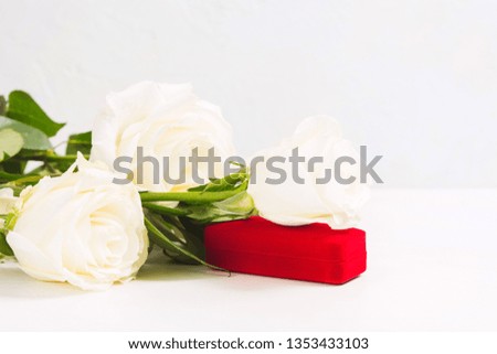 Bouquet of white roses with red gift jewellery box on white texture background with copy space. 8th march, valentines day or womans day concept