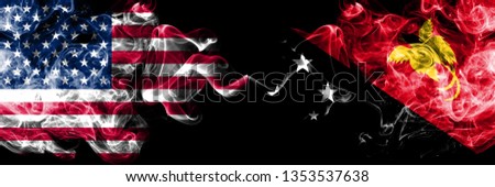 United States of America vs Papua New Guinea smoky mystic flags placed side by side. Thick colored silky smoke flags of America and Papua New Guinea.