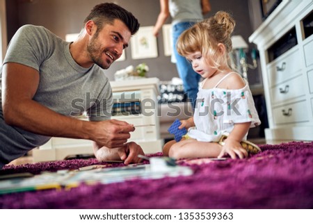 Young man with his child playing with puzzles