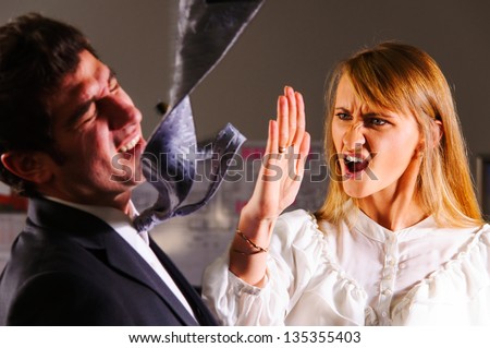 angry businesswoman is slapping across the businessman's face Royalty-Free Stock Photo #135355403