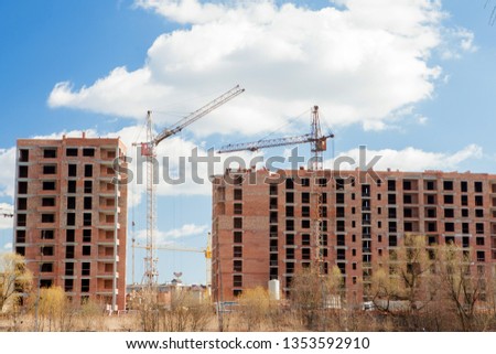 High-rise multi-storey buildings under construction. Tower cranes near building. Activity, architecture, development process, skyscraper.