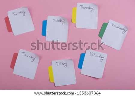 The days of the week - the paper stickers attached to the pink background is; sticker with monday tuesday wednesday thursday friday saturday sunday