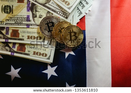 Bitcoin physical coins on American flag background with dollars in the background.