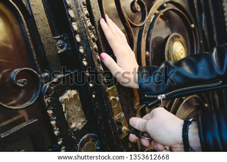 Man's hands trying to open a door by inserting the key into the lock.