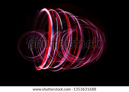 Light painting of red and continuous white spirals forming a 3D shape. Dynamic time trajectory of two lights simultaneously against a black background.