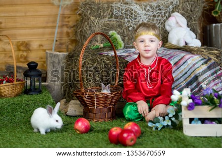 little boy plays with white Easter Bunny. on the green grass and baby bunnies, Spring Festival and birth. living Easter rabbits.