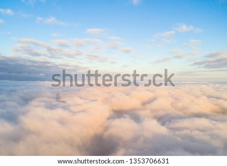 Aerial view White clouds in blue sky. Top view. View from drone. Aerial cloudscape. Texture of clouds. View from above. Sunrise or sunset over clouds Royalty-Free Stock Photo #1353706631