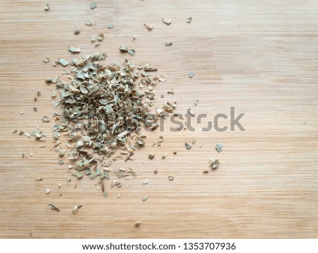 A pile of dried oregano leaves, the famous mediterranean herbs on a wooden table -  Top view
