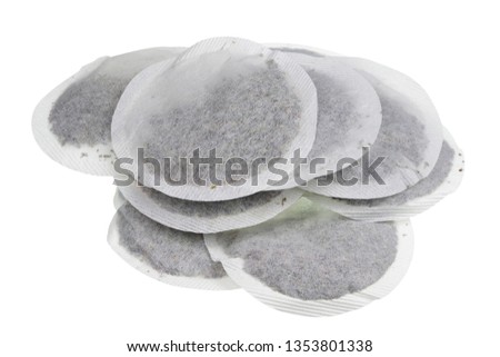 Round paper bags with dry green tea heap. Isolated on white studio macro shot