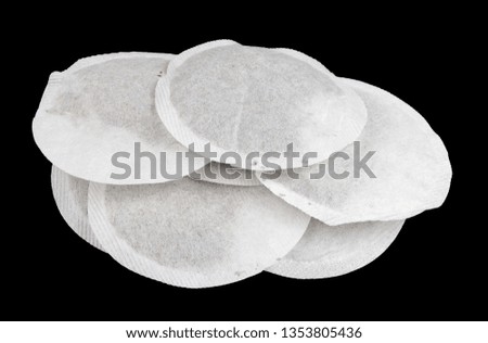 Round paper bags with dry green tea heap. Isolated on black studio macro shot