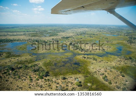 Series of photos taken on Scenic flight in light aircraft over Okavango Delta in Botswana Africa while on camping safari tour. Blue skys, blue water and river, green grass and elephants