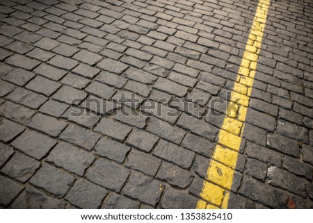 Yellow line on paving stone as abstract background .