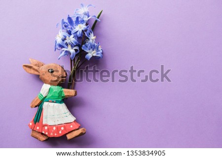 Easter bunny with bouquet of blue spring flowers. Free copy space. Decorative concept