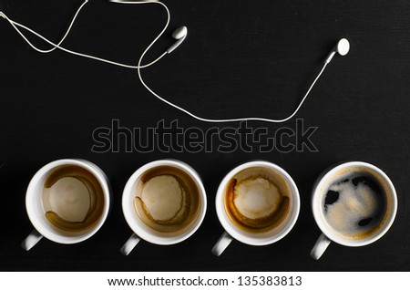 working hours. empty and full cups of fresh espresso with headphones, view from above