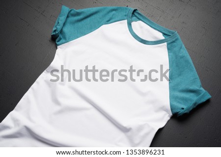 Front view of American Hipsters retro classic clothes. Clean vintage folded t-shirt lies on a black wooden table background