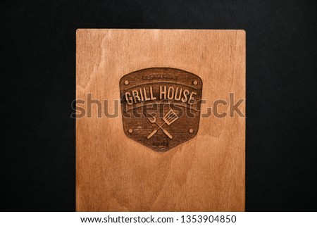 A wooden leather pocket for restaurant and cafe invoices. inscription a grill house on a tree. handmade,