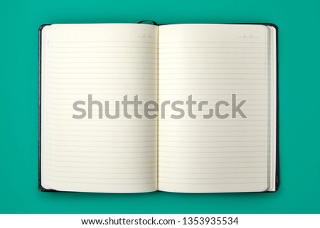 Opened Lined Blank Notebook On Green Background Royalty-Free Stock Photo #1353935534