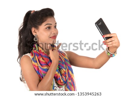 Young Indian girl using a mobile phone or smartphone isolated on a white background