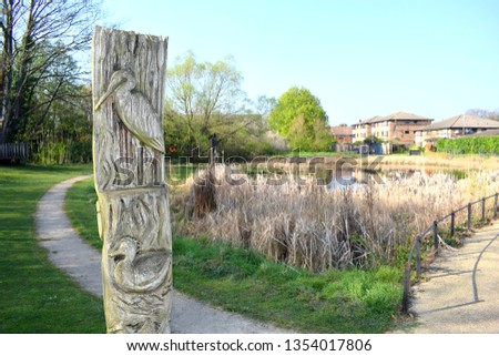 Forest Gate, London, UK - March 29 2019: Beautiful animal themed wood carving totem pole in park in Forest Gate, London, E7 Royalty-Free Stock Photo #1354017806