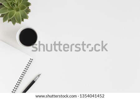 Workspace accessories, coffee and a succulent plant on a white table.  Flat lay with blank copy space. Royalty-Free Stock Photo #1354041452