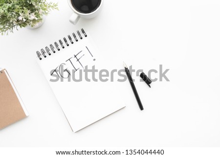 Notebook with TGIF text is on top of white office desk table with pen, cup of coffee and supplies. Top view with copy space, flat lay. TGIF, Friday motivation concept. Royalty-Free Stock Photo #1354044440