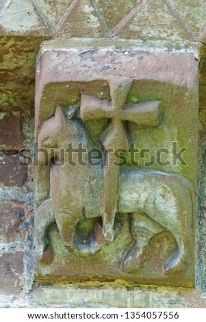 Carving of lamb and cross on the  exterior and under the eaves of The Church of St Mary and St David built in the 12th century, Kilpeck, Herefordshire, England, UK 