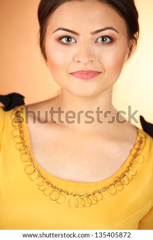 Portrait of a beautiful young woman in a brown background