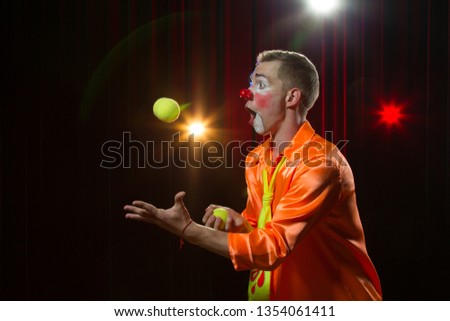 Circus clown performs number. Clown man juggles Royalty-Free Stock Photo #1354061411
