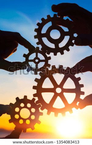 gears in the hands of people against the sky. the mechanism of interaction.