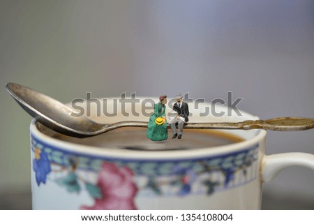 Miniature people: Romantic lovers couple sitting on a sip of black coffee