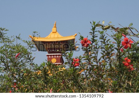a gold and brown tibetan buddhist arch on a background of blue sky