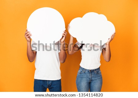 Couple holding speech bubbles, closing faces over orange background