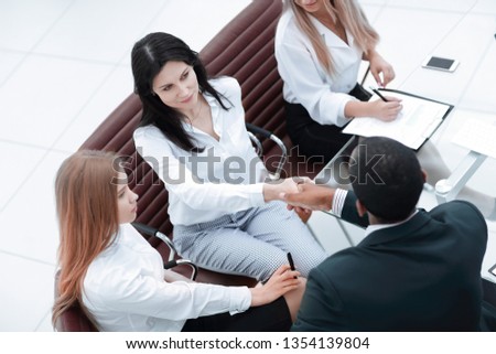 businesswoman shaking hands with partner at office meeting