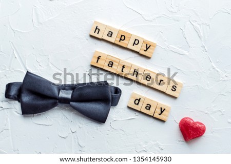 Man's tie, red heart and father's day inscription on white background