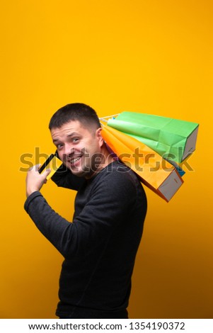 Photo of man with bank card and multi-colored shopping bags