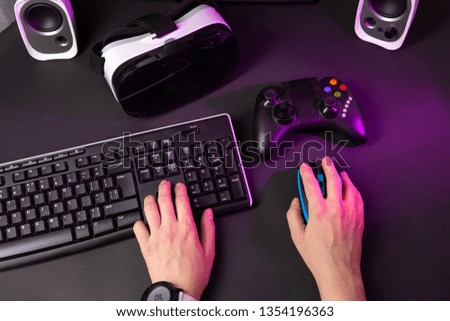 Female hands playing computer game with mouse and keyboard.
