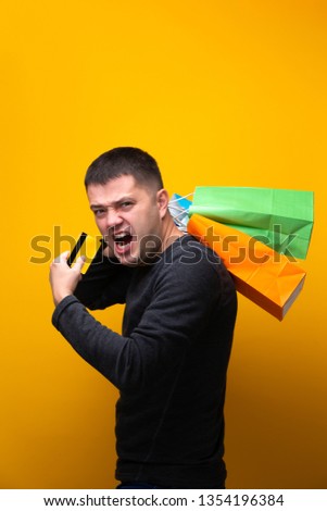 Photo of man with bank card and multi-colored shopping bags