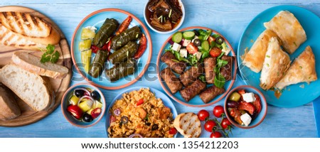 Various Greek dishes on a blue wooden background