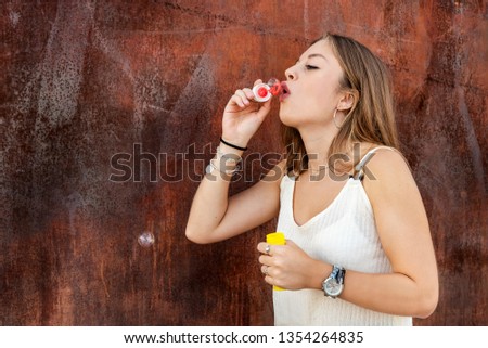Beautiful young woman playing with a bubble blower. Lifestyle concept.