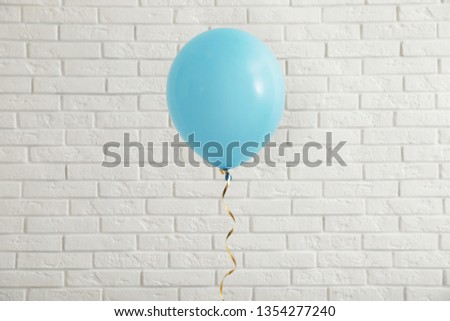 Bright balloon near brick wall. Celebration time