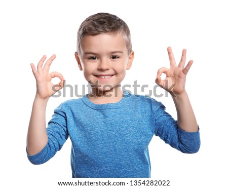 Little boy showing OK gesture in sign language on white background
