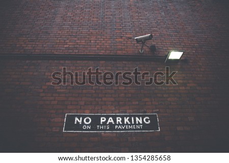 No Parking Sign on Red Brick Wall