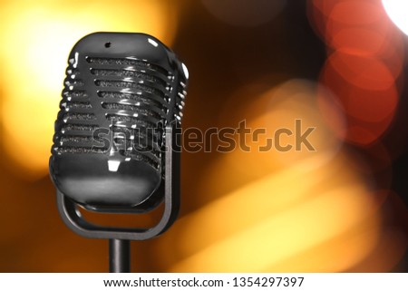 Retro microphone against festive lights, space for text. Musical equipment